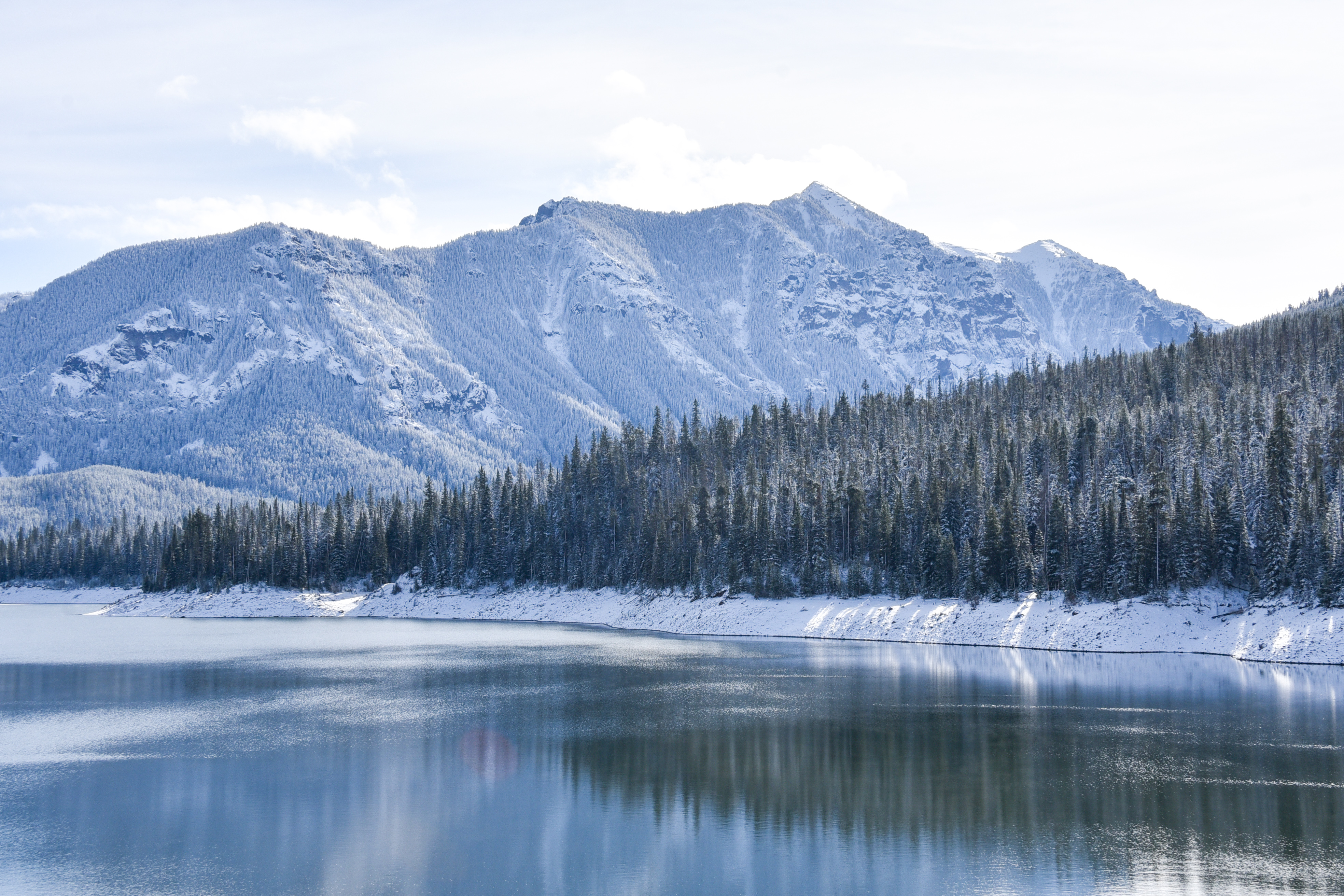Snow-covered mountain peaks reflected in a still alpine lake
